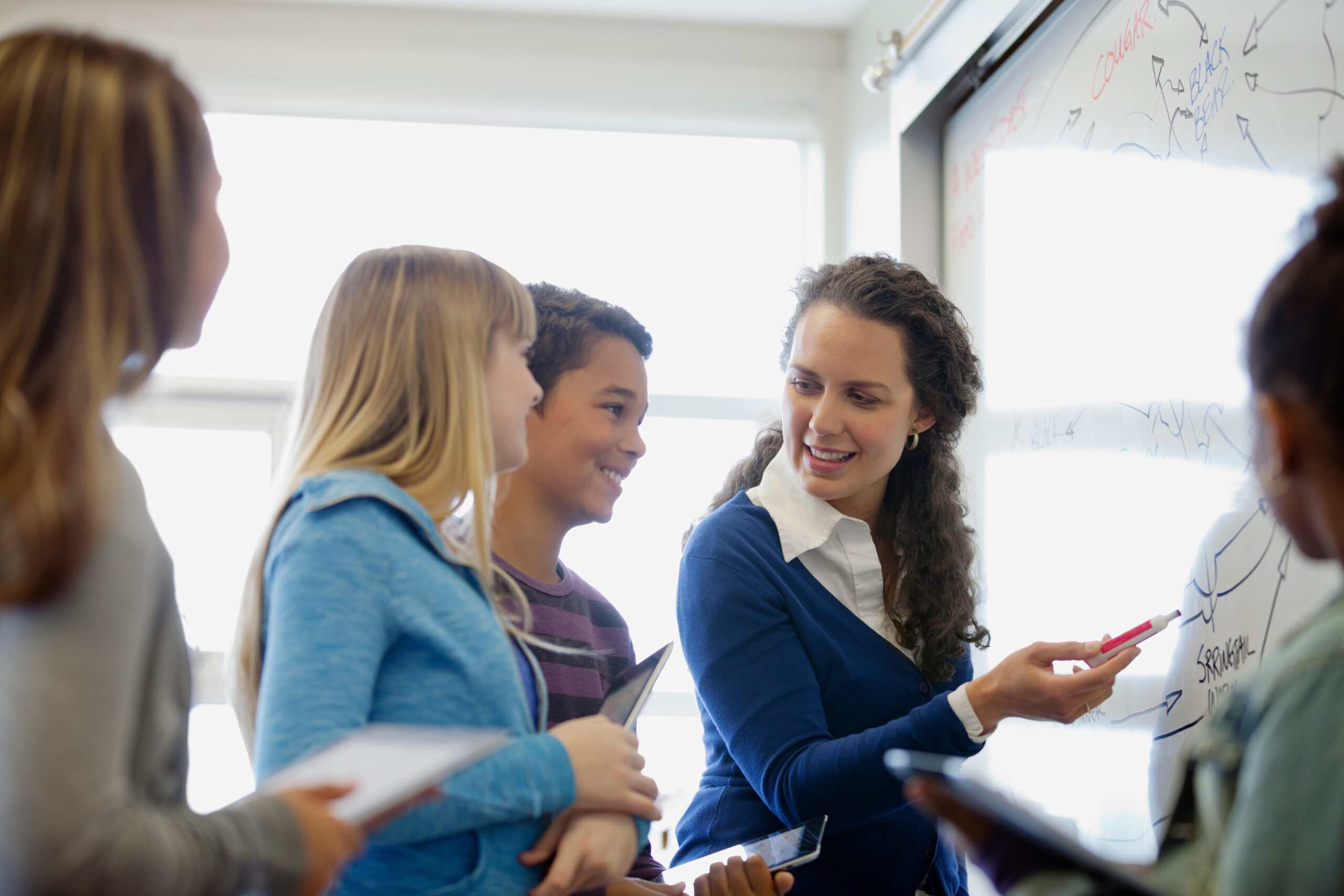 Un(e) enseignant(e) explique la leçon aux élèves.